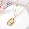 Gros plan d'un pendentif Marie doré avec strass multicolores sur socle géométrique - Style 3 Vierge Marie Ovale avec Zircones Colorées