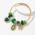 Bracciale dorato con perline, cristalli verdi, ciondoli a farfalla e religiosi - Verde