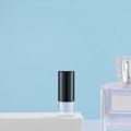 Transparent glass roller bottle with a black cap on a blue background pedestal - 1ml Black