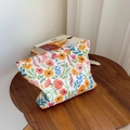 Detailed view of floral canvas makeup bag with vibrant prints and woven texture - Red Orange Small Flowers