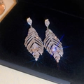 Gros plan de boucles d'oreilles plume en argent avec zircone sur velours noir - Style Longue Goutte de Plume en Diamant Argenté (34#)