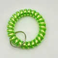 Detailed macro of fluorescent green spiral plastic wristband with metal key ring loop - Metallic Green
