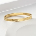 Dettaglio del bracciale in acciaio al titanio dorato con trama a rete e motivo corona - Oro