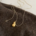Macro detail of brushed gold hulu gourd pendant on a matching snake chain necklace - Gold