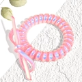 Close-up of pink iridescent spiral hair tie featuring a matching plastic bow detail - Watermelon red