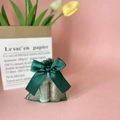 Green organza gift pouch with a matching satin bow holding small cosmetic bottles - Dark Green