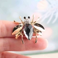 Golden bee insect brooch featuring a large teardrop-shaped black faceted gemstone - Gray