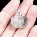 Handcrafted grey labradorite pumpkin pendant with silver loop held in hand - Labradorite