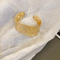 Vista detallada de un brazalete ancho dorado con una superficie martillada y texturizada - Estilo Plisado Dorado (151#)
