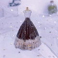 Macro shot of princess dress figurine with black resin skirt and gold glitter flakes - Obsidian