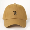 Detailed close-up of 7L embroidery on a khaki cotton twill baseball cap with reinforced stitching - One Size / Turmeric
