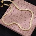 Elegant gold tennis chain necklace with rectangular white zircon stones on pink display - Gold