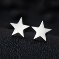 Macro shot of polished silver star earrings on a premium black leather texture background - Pentagram / Silver
