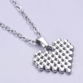 Foto macro de colgante de corazón plateado con textura de cuentas en cadena de acero inox - Collar Plateado