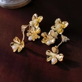Macro detail of gold flower earrings with metallic petals and pearl center accents - Gold Flower Pearl Drop (925 Silver Pin)