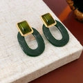 Makroaufnahme dunkelgrüner ovaler Harzohrringe mit goldenem Rechteckstecker auf beigem Stoff - Grüne Harz Geometrische Ohrstecker (925 Silberstift)