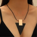 Nahaufnahme der geometrischen Halskette mit schwarzer Kordel und passenden Ohrsteckern am Model - 03 KC Gold Schwarz Gold Kontrast Dreieck Halskette