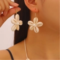 Primo piano di orecchini a fiore con conchiglie e perla indossati da una modella - Stile Orecchini (Oro KC)