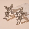 Close-up of silver butterfly and flower clip-on earrings with crystals on stone - Silver Butterfly Flower Leaf Ear Clip