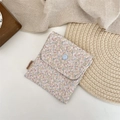 Close-up of a floral cotton organizer pouch with a button closure and brand side label - Large Floral