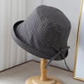 Detailaufnahme der Plaid-Textur und Schleife des grauen Sonnenhutes auf einem Holzständer - M (56-58 cm) Verstellbar / Schwarz Kariert