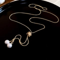 Detail of gold snake chain necklace featuring two large pearls and a crystal paved ball - Gold