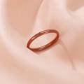 Macro shot of rose gold minimalist slim ring on soft pink satin fabric background - Brown