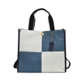 Sac fourre-tout en denim bleu et blanc avec anses noires sur un fond blanc neutre - Bleu clair