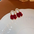 Macro view of red flocked bow earrings featuring white pearls and elegant gold tassels - Red Flocked Bow Pearl