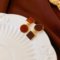 Detail of vintage geometric earrings with amber resin on a decorative white porcelain plate - Coffee Square Round