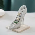Macro shot of silver glitter high heel jewelry stand with gray velvet ring slots - Silver Texture