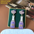 Detailed view of purple wine bottle earrings with pearls on green velvet display - 628 Purple Wine Bottle