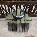 Detailed close-up of natural green stones and black moon crescent on a metal hair comb - Prehnite Black Moon