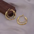 Elegant gold double hoop earrings with layered nested circles on grey silk fabric - Double-Layer Ring Structure / E-068---Gold