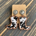 Detail of western cowboy boot earrings featuring cow print inlay and wooden textures - Black White Cow Print