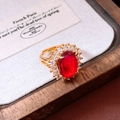 Detail of a vintage 24k gold plated ring with oval red gemstone and zircon halo - Ruby Oval Style