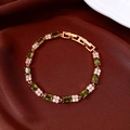 Detail of 18k gold plated bracelet with green zircons on red silk background - Bracelet-Gold-Green-Real Gold Plated
