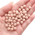 Pink matte acrylic round beads held in hand for DIY necklace and bracelet crafting - Dried Orange Rose
