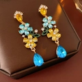 Nahaufnahme von Vintage-Ohrringen mit Blumen, blauen und gelben Strasssteinen - 925 Silberstift - Blau & Gelb