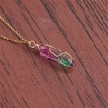 Detalle de un colgante de cristal púrpura y verde envuelto en alambre dorado sobre madera - A-NSN0226 Cadena en O de Acero Inoxidable Dorado