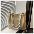 Detailansicht der beigen Strohtasche mit dicken Seilgriffen und modischem PU-Lederaufnäher - Khaki