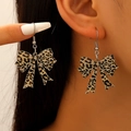 Leopard print bow earrings with alloy hooks shown being worn to display size and fit - Tan Leopard Bow (02 White K 11960)