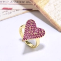 Macro shot of gold-plated heart ring featuring pink cubic zirconia on a white table - Pave Heart Style-Pink Stone (ZYN-DMR119G-2)