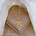 Detail showing starfish necklace dimensions 2.5x2cm and 3.6g weight on white silk - Gold Rotating Starfish Style (C416)
