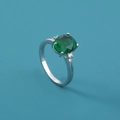 Macro shot of silver ring with oval green gemstone and white zircon side stones - Adjustable Open / Green Oval Gemstone/Silver Band