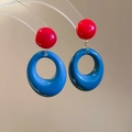 Detailed view of red and blue resin oval drop earrings with polished ceramic texture - Blue