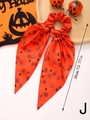 Detail of Halloween hair scrunchie with long ribbons featuring orange ghost and spider web prints - Style J