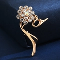 Detailed view of a golden flower brooch with rhinestones on dark blue velvet - Colorful Rhinestone Flower
