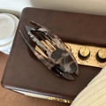 Brown leopard print large PC hair claw clip placed on a vintage speaker surface - Grey Tortoiseshell Swallowtail Clip