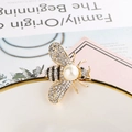 Detailed close-up of a bee brooch featuring gold alloy, sparkling rhinestones, and pearls - Exquisite Pearl Bee
